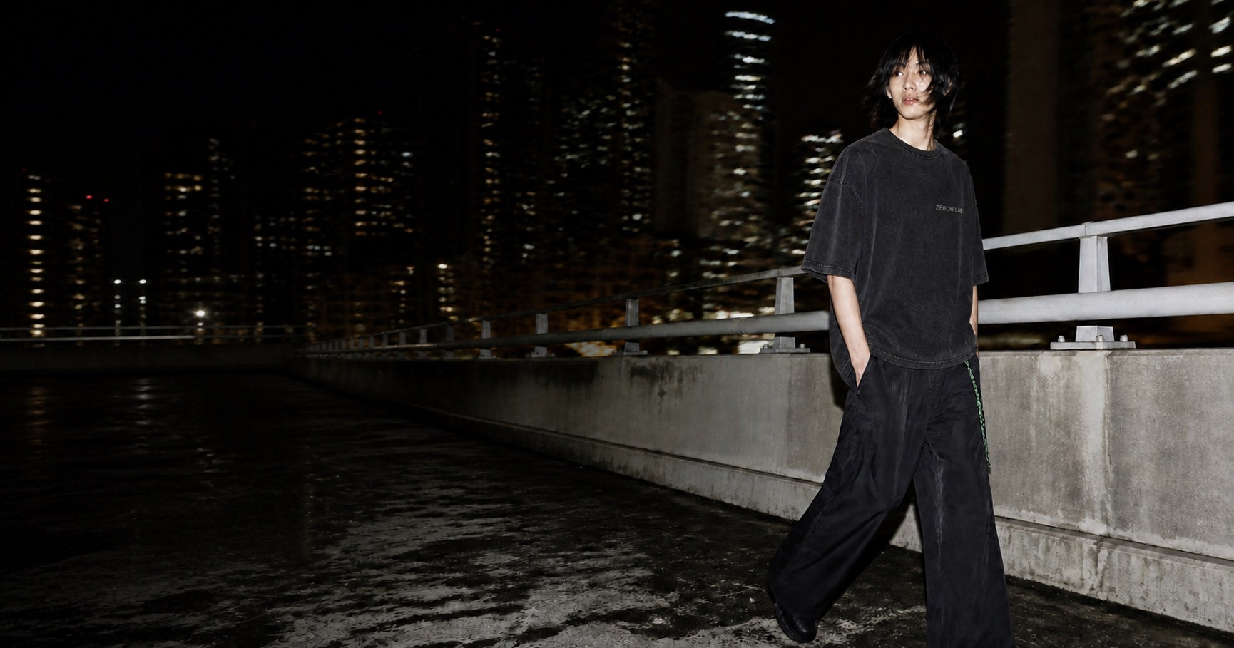Model wearing a black Zeron T-shirt on a Hong Kong rooftop at night